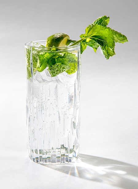 Image shows a Mojito drink with mint and lime garnish