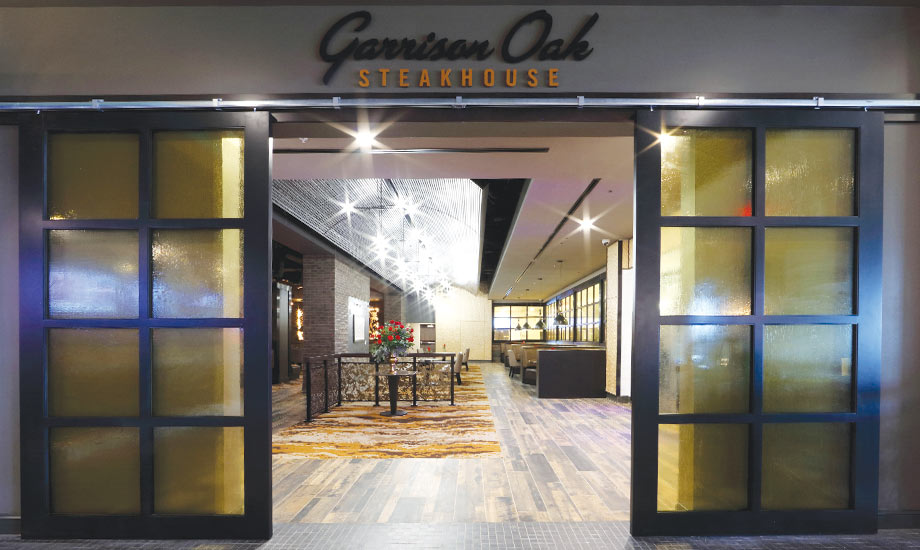 Image shows the entrance to Garrison Oak Steakhouse peeking into the dining area