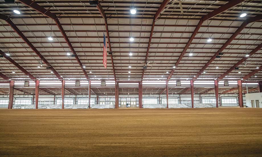 Image shows indoor show ring at Equestrian Center with bleacher seating.