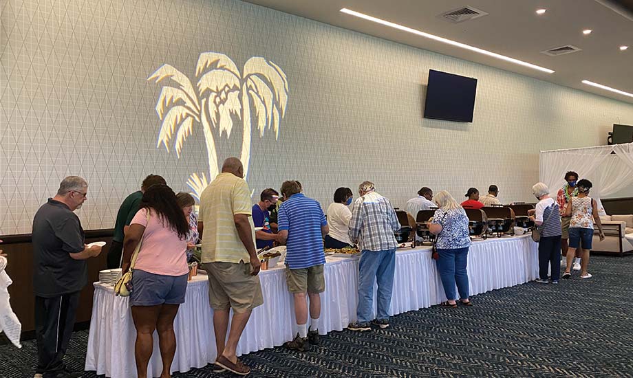 Image shows guests in the Grandstand event area grabbing food from a buffet table