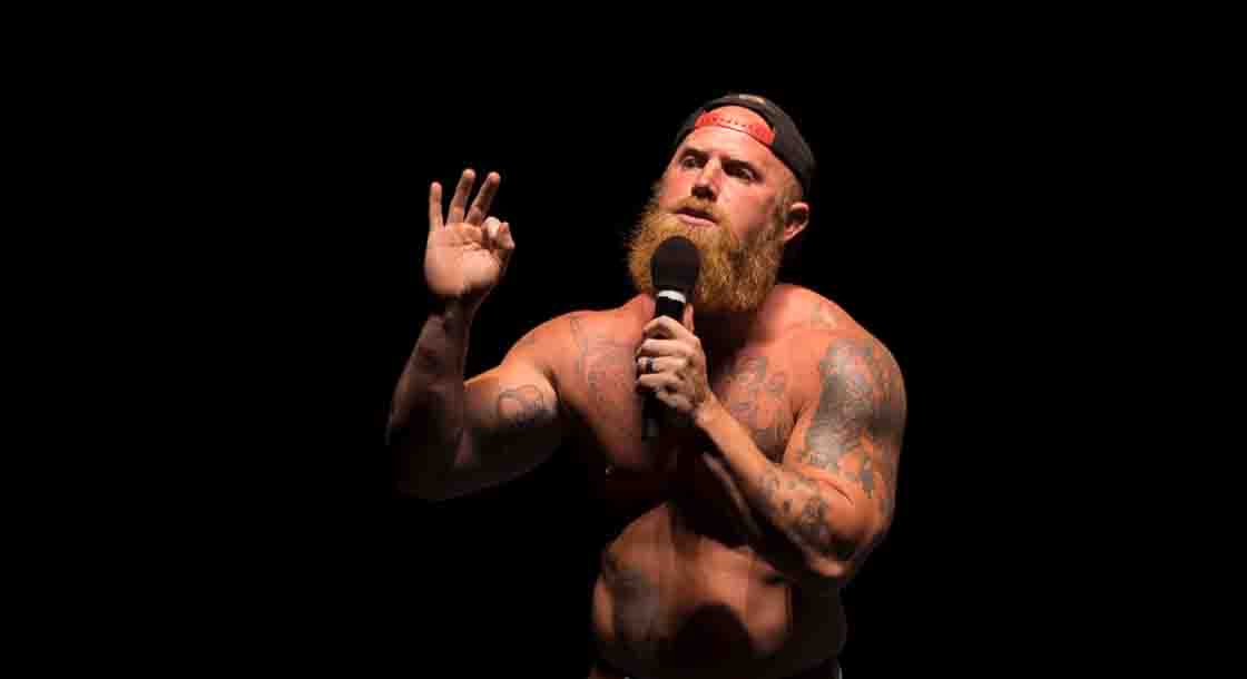 Photo is Image of shirtless red headed man , Ginger Billy, with black background.
